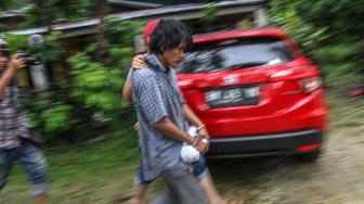 Petugas Direktorat Reserse Narkoba Polda Riau membawa dua orang pelaku pembuat narkoba ketika menggerebek sebuah rumah yang dijadikan tempat pembuatan narkoba jenis pil Happy FIve (H5) di Pekanbaru, Riau, Rabu (27/11). [ANTARA FOTO/Rony Muharrman]