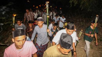 Warga membawa obor sambil berzikir mengelilingi pelosok perkampungan di Desa Paya Punteuet, Muara Dua, Lhokseumawe, Aceh, Kamis (28/11) malam. [ANTARA FOTO/Rahmad]