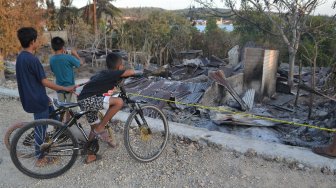 Sejumlah anak melihat puing-puing rumah yang dibakar akibat keributan antar warga di Desa Wadiabero, Kecamatan GU, Kabupaten Buton Tengah, Sulawesi Tenggara, Kamis (28/11). [ANTARA FOTO / Rj / Jojon]