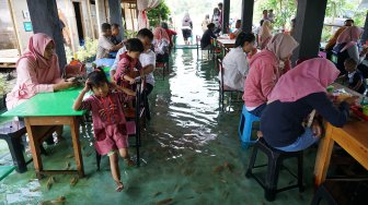 Pengunjung menikmati suasana warung makan yang berada di dalam kolam ikan di Sawahan Lor, Wedomartani, Ngemplak, Sleman, DI Yogyakarta, Sabtu (30/11). [ANTARA FOTO/Hendra Nurdiyansyah]