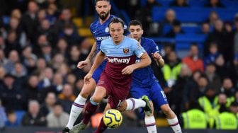 Striker Chelsea asal Prancis Olivier Giroud (kiri) bersaing dengan gelandang Inggris West Ham United Mark Noble selama pertandingan sepak bola Liga Premier Inggris antara Chelsea dan West Ham United di Stamford Bridge di London pada 30 November 2019. [Ben STANSALL / AFP]