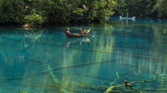 Pengunjung berkeliling dengan perahu di obyek wisata Danau Paisupok di Desa Lukpanenteng, Kabupaten Banggai Kepulauan, Sulawesi Tengah, Selasa (3/12). [ANTARA FOTO/Basri Marzuki]