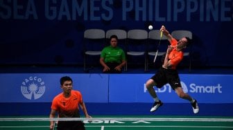 Ganda putra Indonesia Muhammad Rian Ardianto (kanan) dan Fajar Alfian mengembalikan kok ke arah ganda putra Malaysia Aaron Chia Teng Fong dan Soh Wooi Yik dalam final bulu tangkis beregu putra SEA Games 2019 di Kompleks Olahraga Muntinlupa, Manila, Filipina, Rabu (4/12).[ANTARA FOTO/Sigid Kurniawan]