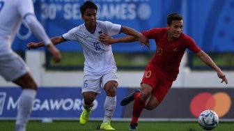 Pemain Timnas U-22 Indonesia Eggy Maulana Vikri (kanan) menggiring bola dibayangi pemain Timnas Laos Somlith Sengvanny dalam pertandingan Grup B SEA Games 2019 di Stadion City of Imus Grandstand, Filipina, Kamis (5/12). [ANTARA FOTO/Sigid Kurniawan]