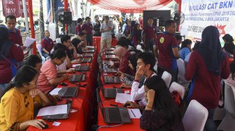 Peserta mengikut simulasi tes Calon Pegawai Negeri Sipil (CPNS) berbasis Computer Assisted Test (CAT) saat car free day di Kawasan Sarinah, Jakarta, Minggu (8/12). [ANTARA FOTO/Galih Pradipta]