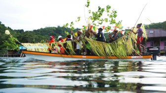 Warga melakukan prosesi adat dengan perahu hias berkunjung ke setiap rumah, di Distrik Kepulauan Ambai, Kepulauan Yapen, Sabtu (07/12). [ANTARA FOTO/Indrayadi TH]