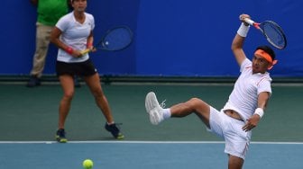 Petenis ganda campuran Indonesia Christopher Rungkat (kanan) dan Aldila Sutjiadi mengembalikan bola ke arah ganda campuran Thailand Sanchai Ratiwatana dan Tamarine Tanasugarn dalam babak final ganda campuran SEA Games 2019 di lapangan Rizal Memorial Tennis Center, Manila, Filipina, Sabtu (7/12). [ANTARA FOTO/Sigid Kurniawan]