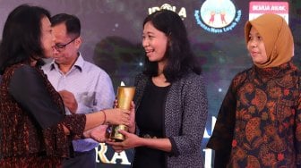 Asisten Redaktur Pelaksana sekaligus perwakilan dari Suara.com, Ririn Indriani (kedua kanan) menerima piala penghargaan Piala Merak 2019 yang diberikan oleh Menteri Pemberdayaan Perempuan dan Perlindungan Anak Republik Indonesia, Bintang Puspayoga (kiri) saat Malam Penganugerahan Piala Merak 2019 di Wisma Antara, Jakarta Pusat, Senin (9/12).  [Suara.com/Angga Budhiyanto]