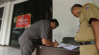 Petugas Badan Pajak dan Restribusi Daerah (BPRD) DKI Jakarta berada di sekitar stiker 'Objek Pajak' saat Supervisi pencegahan pajak di kantor Banteng Muda, Benhil, Jakarta Pusat, Senin (9/12). [Suara.com/Angga Budhiyanto]