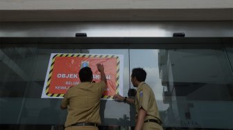 Petugas Badan Pajak dan Restribusi Daerah (BPRD) DKI Jakarta berada di sekitar stiker 'Objek Pajak' saat Supervisi pencegahan pajak di kantor Banteng Muda, Benhil, Jakarta Pusat, Senin (9/12). [Suara.com/Angga Budhiyanto]