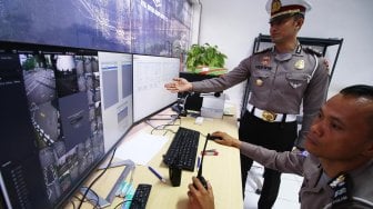 Kepala Seksi SIM Subdit Regident Ditlantas Polda Metro Jaya AKP Lalu Hedwin (kiri) memantau berlangsungnya uji praktik SIM sistem elektronik melalui CCTV di Satuan Penyelenggara Administrasi (Satpas) SIM Daan Mogot, Jakarta, Selasa (10/12). [ANTARA FOTO/Rivan Awal Lingga]