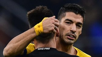 Pemain depan Barcelona Luis Suarez menghibur pemain depan Inter Milan Lautaro Martinez pada akhir pertandingan sepak bola Grup F Liga Champions Inter Milan melawan Barcelona di Giuseppe Meazza, Milan, Italia, Rabu (11/12) dini hari WIB. [Miguel MEDINA / AFP]
