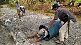 Jalan Rusak Tak Diperbaiki Pemkab, Warga Gelindingkan Diri di  Dalam Tong