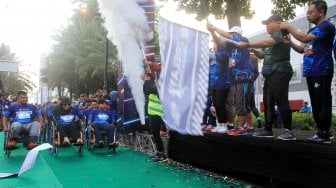 Direktur Utama BPJAMSOSTEK Agus Susanto melepas rombongan peserta lari Disabilitas yang mengikuti BPJAMSOSTEK Relay Marathon 2019 di Epicentrum, Kuningan, Jakarta, Minggu (15/12). [Suara.co/Oke Atmaja]
