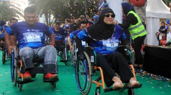 Peserta lari Disabilitas mengikuti BPJAMSOSTEK Relay Marathon 2019 di Epicentrum, Kuningan, Jakarta, Minggu (15/12). [Suara.com/Oke Atmaja]
