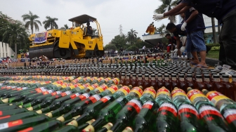 Sejumlah petugas memusnahkan barang bukti minuman keras di Kantor Bea Cukai, Rawamangun, Jakarta, Kamis, (19/12). [Suara.com/Angga Budhiyanto]