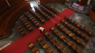 Pekerja membersihkan kursi-kursi untuk jemaat di GPIB Immanuel, Gambir, Jakarta Pusat, Kamis (19/12).[Suara.com/Angga Budhiyanto] 