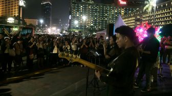 Penyanyi melantunkan lagu lagu natal dalam acara Christmas Carol di Bundaran Hotel Indonesia, Kamis (19/12). [Suara.com/Alfian Winanto]