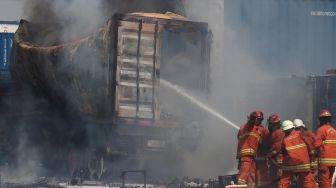 Pemadam Kebakaran Kota Surabaya memadamkan kontainer di atas truk yang terbakar di Depo Tanto Jalan Tanjung Emas No 1 Surabaya, Jawa Timur, Jumat (20/12).  [ANTARA FOTO/Didik Suhartono]