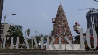 Petugas PPSU menata pohon Natal dari miniatur ondel-ondel yang terbuat dari botol minuman bekas di Food Court Thamrin 10, kawasan Thamrin, Jakarta, Sabtu (21/12). [Suara.com/Angga Budhiyanto]