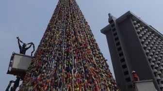 Petugas PPSU menata pohon Natal dari miniatur ondel-ondel yang terbuat dari botol minuman bekas di Food Court Thamrin 10, kawasan Thamrin, Jakarta, Sabtu (21/12). [Suara.com/Angga Budhiyanto]