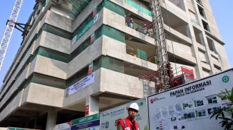 Pekerja menyelesaikan proyek The Padmayana di kawasan Kebayoran Baru, Jakarta Selatan, Sabtu (21/12). [Suara.com/Oke Atmaja]