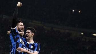 Gelandang Inter Milan Roberto Gagliardini merayakan golnya dengan bek Inter Milan Alessandro Bastoni setelah mencetak gol selama pertandingan sepak bola Serie A Italia antara Inter Milan melawan Genoa di Stadion Giuseppe Meazza, Milan, Italia, Minggu (22/12) dini hari WIB. [Marco BERTORELLO / AFP]
