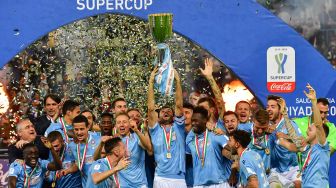 Pemain Lazio mengangkat trofi setelah pertandingan final sepakbola Supercoppa Italia antara Juventus melawan Lazio di Stadion King Saud University, Riyadh, Senin (23/12) dini hari WIB. [GIUSEPPE CACACE / AFP]