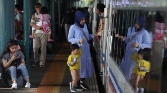 Calon penumpang bergegas memasuki rangkaian kereta api di Stasiun Gambir, Jakarta Pusat, Senin (23/12). [Suara.com/Angga Budhiyanto]