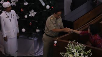 Gubernur DKI Jakarta Anies Baswedan (tengah) bersalaman dengan seorang Jemaat saat misa malam Natal di GPIB Immannuel, Gambir, Jakarta Pusat, Selasa(24/12). [Suara.com/Angga Budhiyanto]