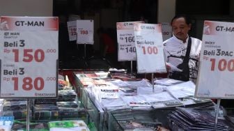 Pengunjung memilih baju di sebuah toko yang menawarkan potongan harga di kawasan Pasar Baru, Jakarta, Selasa (24/12). [Suara.com/Angga Budhiyanto]