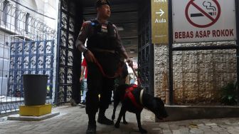 Tim Gegana mengunakan anjing pelacak menyisir kawasan Gereja Katedral Jakarta, Selasa (24/12). [Suara.com/Angga Budhiyanto]