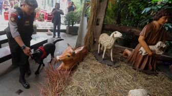 Tim Gegana mengunakan anjing pelacak menyisir kawasan Gereja Katedral Jakarta, Selasa (24/12). [Suara.com/Angga Budhiyanto]