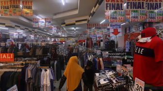 Pengunjung memilih baju di sebuah toko yang menawarkan potongan harga di kawasan Pasar Baru, Jakarta, Selasa (24/12). [Suara.com/Angga Budhiyanto]