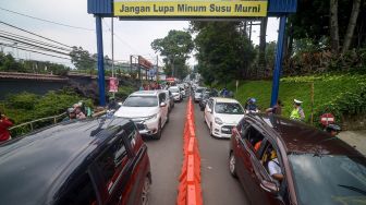 Petugas memberlakukan sistem satu arah untuk mengurai kemacetan di Jalan Setiabudi-Lembang, Kabupaten Bandung Barat, Jawa Barat, Selasa (24/12). [ANTARA FOTO/Raisan Al Farisi]