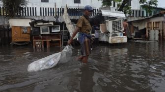 Sejumlah warga beraktivitas di jalan yang terendam banjir di kawasan Sunter, Jakarta Utara, Rabu (25/12). [Suara.com/Angga Budhiyanto]