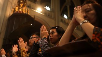 Jemaat memanjatkan doa saat misa Natal di Gereja Katedral, Jakarta, Rabu (25/12).[Suara.com/Angga Budhiyanto]