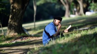 Korban selamat Fikramullah berdoa saat memperingati 15 tahun musibah gempa dan tsunami di kuburan Massal Siron, Aceh, Kamis (26/12). [CHAIDEER MAHYUDDIN / AFP]