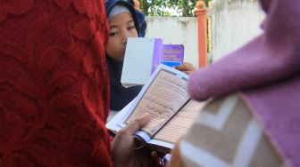 Sejumlah umat muslim membaca Surat Yasin dan doa bersama saat berziarah ke kuburan massal korban gempa dan gelombang tsunami di Desa Suak Indrapuri, Johan Pahlawan, Aceh Barat, Aceh, Kamis (26/12). [ANTARA FOTO/Syifa Yulinnas]