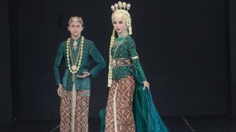 Model dengan busana pengantin dari daerah Bandung di Panggung Kesenian anjungan Jawa Barat, Taman Mini Indonesia Indah, Jakarta Timur (29/12). [Suara.com/Alfian Winanto]