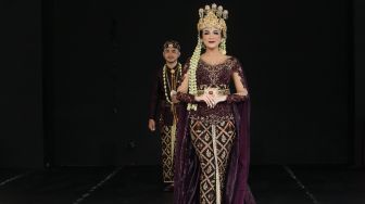 Model dengan busana pengantin dari daerah Bandung Barat di Panggung Kesenian anjungan Jawa Barat, Taman Mini, Jakarta, Minggu (29/12). [Suara.com/Alfian Winanto]