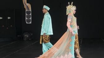 Model yang berjalan di catwalk dalam pagelaran pesona Budaya Jawa Barat, di Panggung Kesenian anjungan Jawa Barat, Taman Mini Indonesia Indah, Jakarta Timur (29/12). [Suara.com/Alfian Winanto]