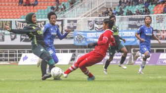 Pesepak bola Tira Persikabo Kartini Insyafada (kiri) berusaha menendang bola yang dihadang kiper Persib Bandung Putri Vivi Oktavia (kanan) dalam babak final leg ke-2 Liga 1 Putri 2019 di Stadion Pakansari, Cibinong, Bogor, Jawa Barat, Sabtu (28/12). [ANTARA FOTO/Yulius Satria Wijaya]