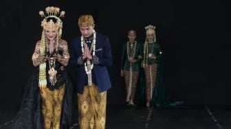 Model yang berjalan di catwalk dalam pagelaran pesona Budaya Jawa Barat, di Panggung Kesenian anjungan Jawa Barat, Taman Mini Indonesia Indah, Jakarta Timur (29/12). [Suara.com/Alfian Winanto]