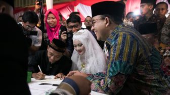 Prosesi simbolik nikah massal yang dipimpin langsung oleh Gubernur DKI Jakarta Anies Baswedan di acara nikah massal yang ada di Balaikota, Gambir, Jakarta Pusat, Selasa (31/12). [Suara.com/Alfian Winanto]