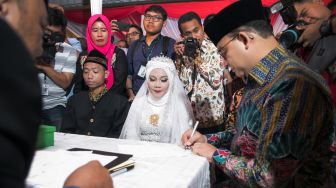 Prosesi simbolik nikah massal yang dipimpin langsung oleh Gubernur DKI Jakarta Anies Baswedan di acara nikah massal yang ada di Balaikota, Gambir, Jakarta Pusat, Selasa (31/12). [Suara.com/Alfian Winanto]