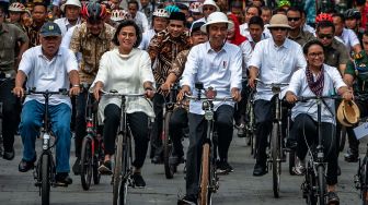 Presiden Joko Widodo (tengah) didampingi Menteri Luar Negeri Retno Marsudi (kanan), Menteri Keuangan Sri Mulyani (kedua kiri), Menteri PUPR Basuki Hadimuldjono (kiri) naik sepeda ontel di Kawasan Kota Lama Semarang, Jawa Tengah, Senin (30/12). [ANTARA FOTO/Aji Styawan]