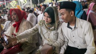 Para pasangan yang menghadiri acara nikah massal yang ada di Balaikota, Gambir, Jakarta Pusat, Selasa (31/12). [Suara.com/Alfian Winanto]