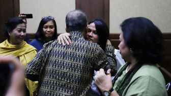 Mantan Dirut Utama PT Garuda Indonesia (persero) Tbk, Emirsyah Satar, memeluk keluarga usai menjalani sidang perdana dengan agenda pembacaan dakwaan di Pengadilan Tipikor, Jakarta Pusat, Jakarta, Senin (30/12).  [Suara.com/Alfian Winanto]