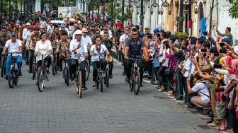 Presiden Joko Widodo (tengah) didampingi Menteri Luar Negeri Retno Marsudi (kanan), Menteri Keuangan Sri Mulyani (kedua kiri), Menteri PUPR Basuki Hadimuldjono (kiri) naik sepeda ontel di Kawasan Kota Lama Semarang, Jawa Tengah, Senin (30/12). [ANTARA FOTO/Aji Styawan]